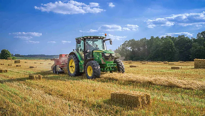 Traktor kjører på jordet